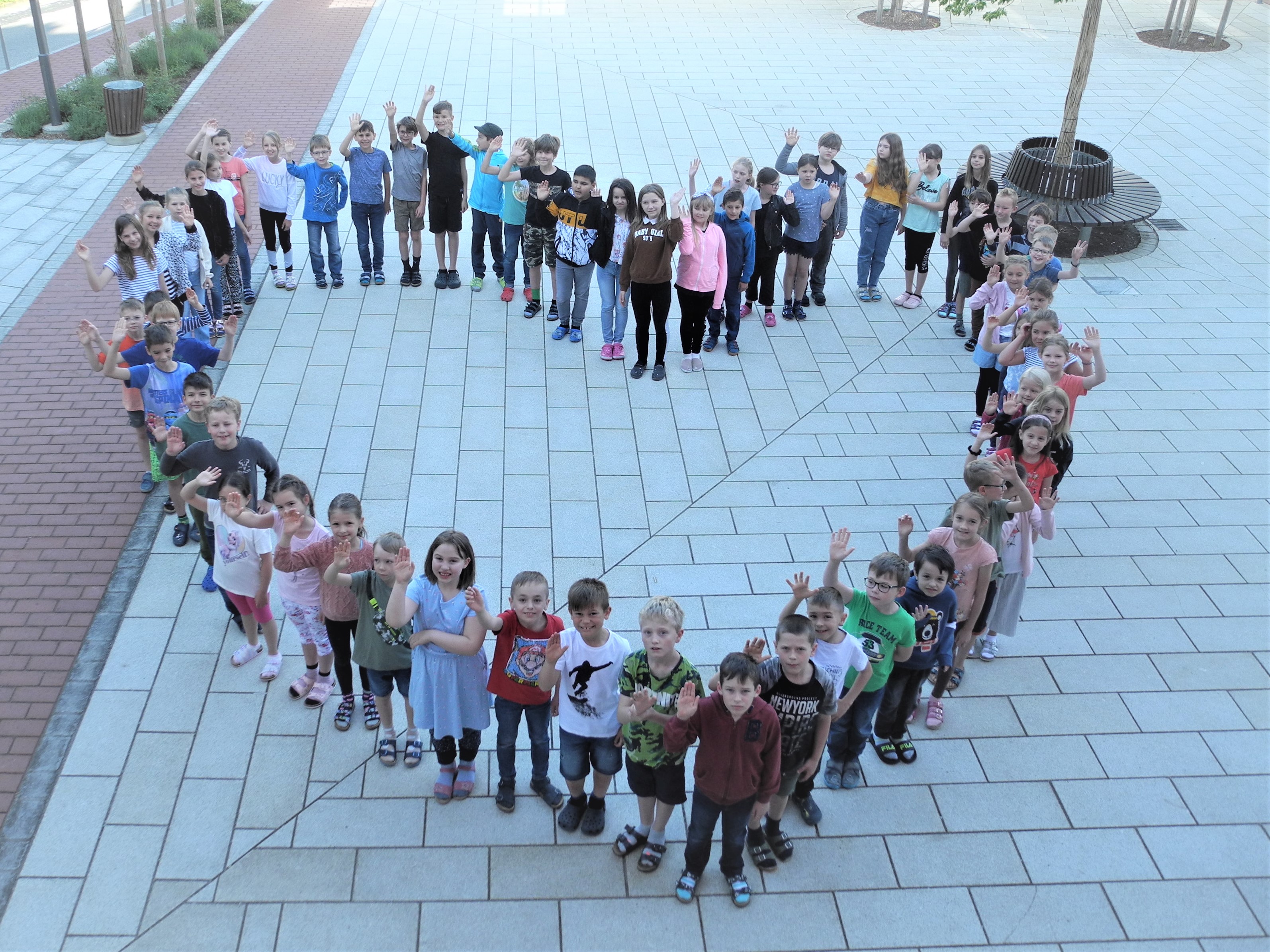 Schulkinder stellen sich in Herzform auf (2022)